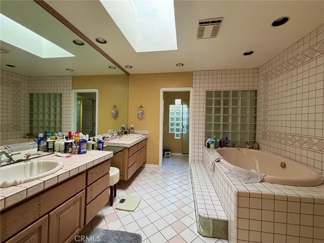 a large bathroom with a tub sink and mirror