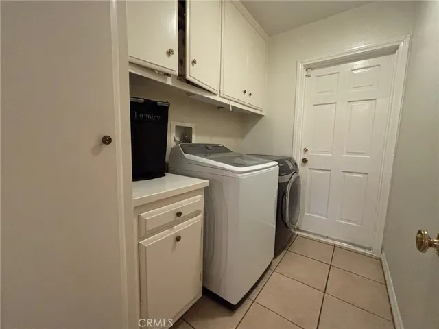 a utility room with cabinets washer and dryer