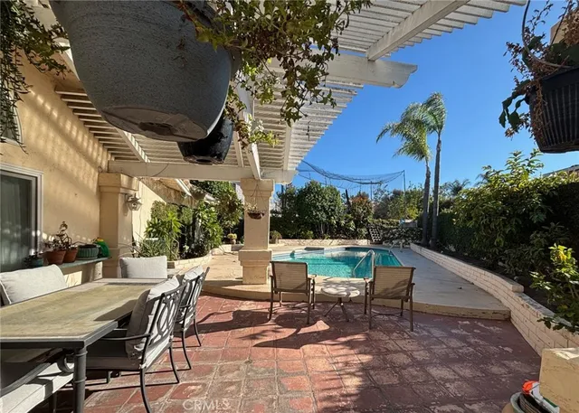 a view of a patio with a table and chairs under an umbrella