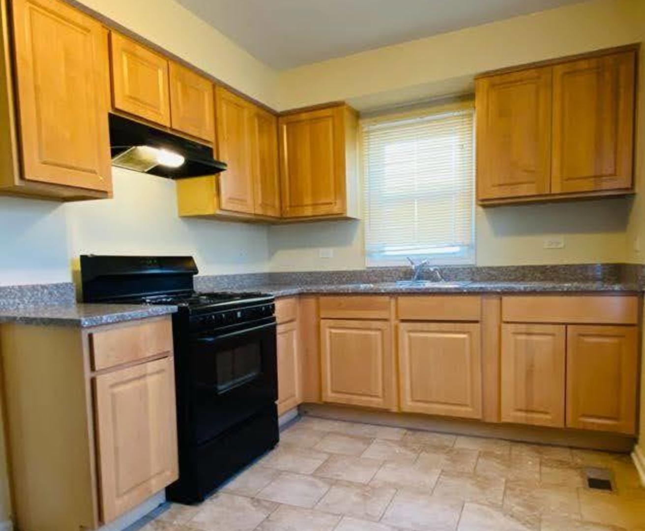 17543 Roy Street Lansing, IL 60438 - Photo 5 of 13 a kitchen with stainless steel appliances granite countertop a stove a sink and a microwave