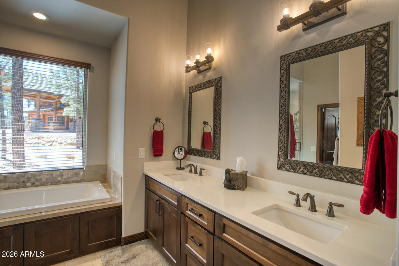 4880 West Hawthorn Road Show Low, AZ 85901 - Photo 9 of 42 a bathroom with a tub double sink window and mirror