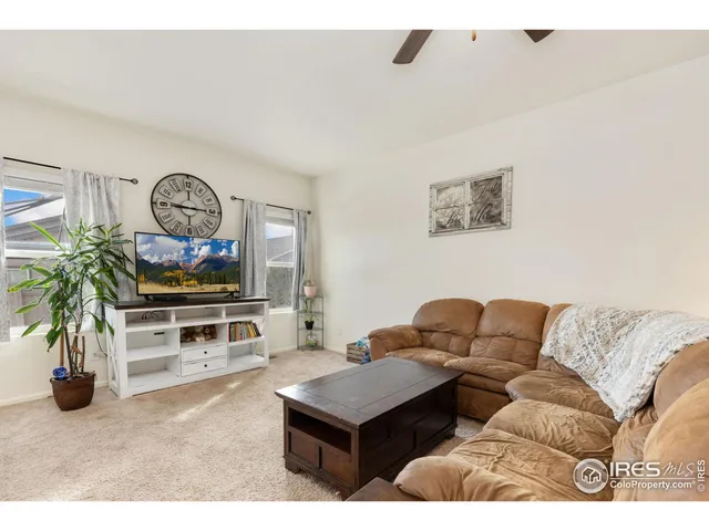 a living room with furniture a window and a flat screen tv