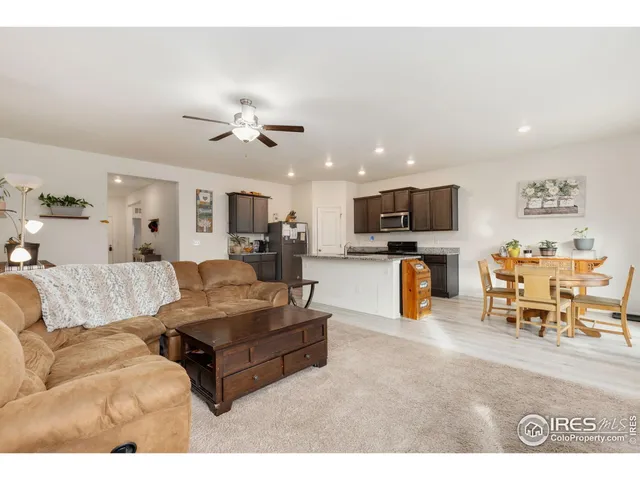 a living room with furniture kitchen view and a flat screen tv