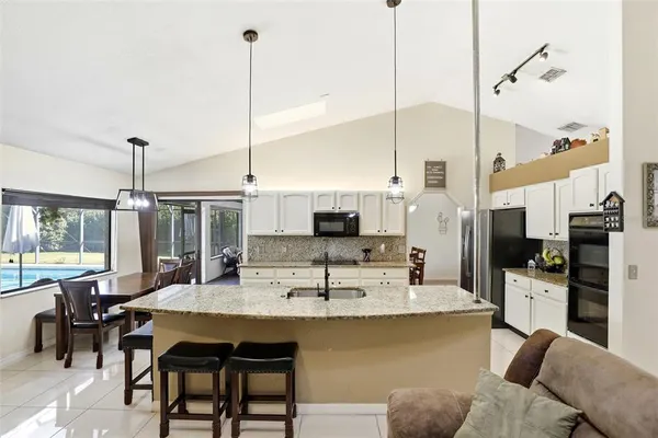 a dining room with furniture a chandelier and wooden floor