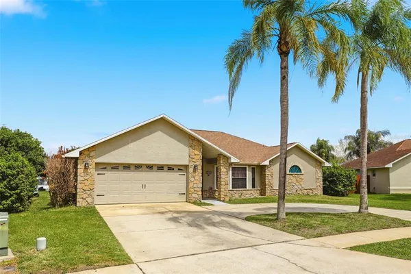 a view of a house with a yard and palm trees