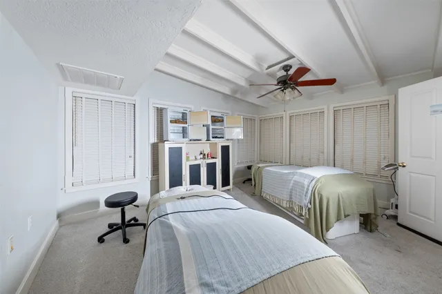 a spacious bedroom with a bed and a chandelier