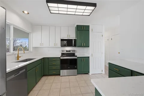 a kitchen with stainless steel appliances granite countertop a sink and a stove
