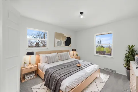 a bedroom with a large bed and a painting on the wall