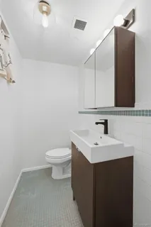 a bathroom with a sink a toilet and mirror