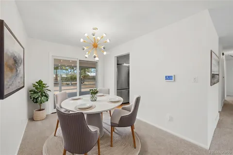 a dining room with furniture potted plants and wooden floor
