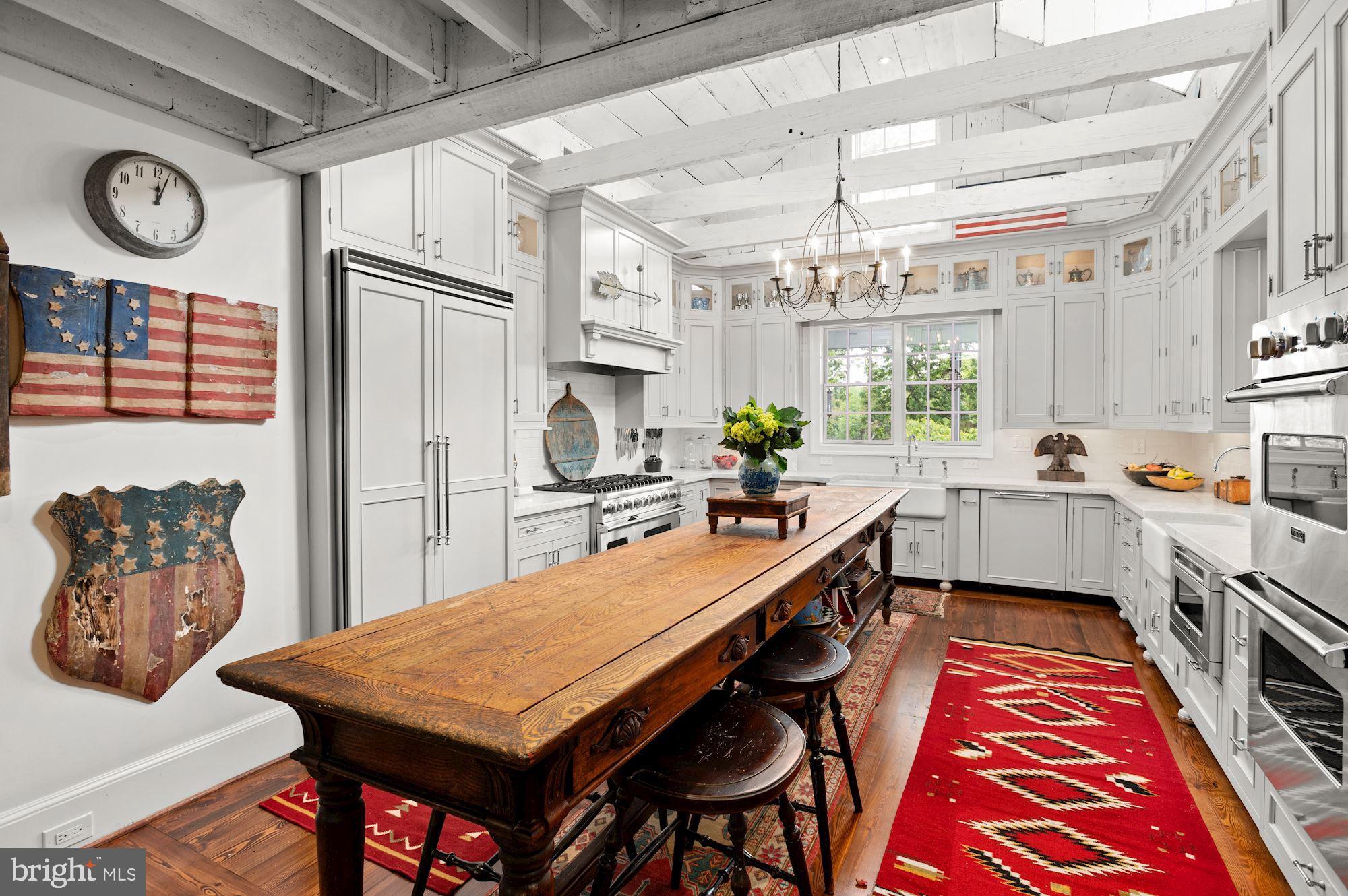 1101 Chain Bridge Road McLean, VA 22101 - Photo 11 of 54 a kitchen with stainless steel appliances a table chairs and a chandelier