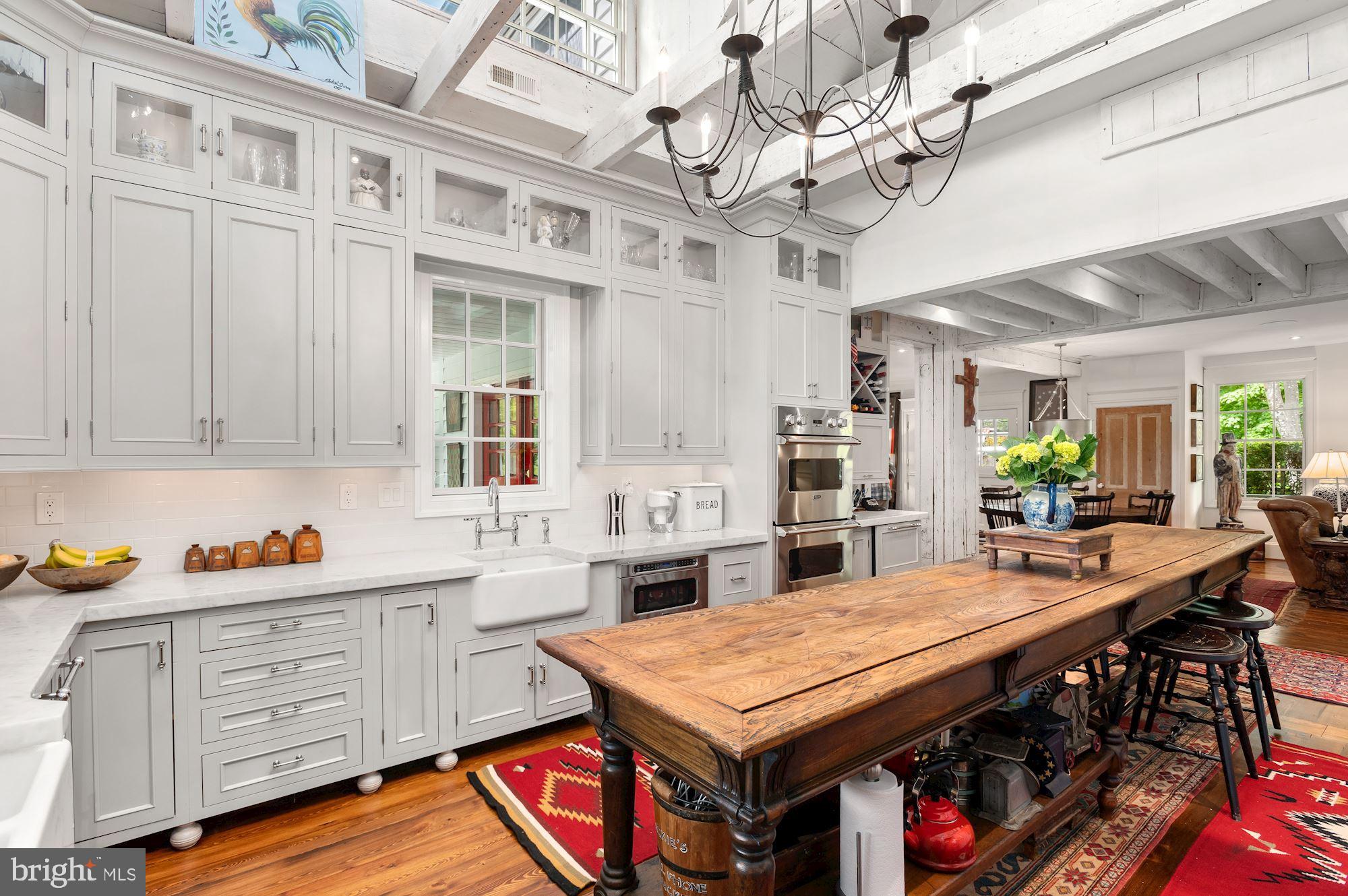 1101 Chain Bridge Road McLean, VA 22101 - Photo 12 of 54 a kitchen with stainless steel appliances granite countertop a dining table and chairs in it