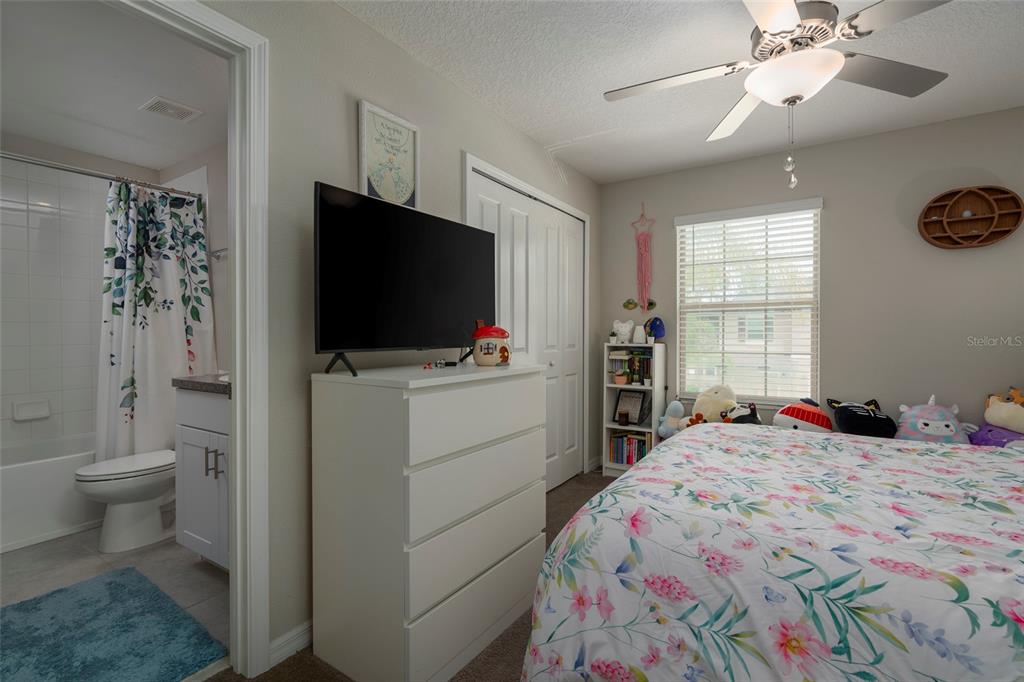 11704 Castine Street New Port Richey, FL 34654 - Photo 29 of 31 a bedroom with a bed and a flat screen tv