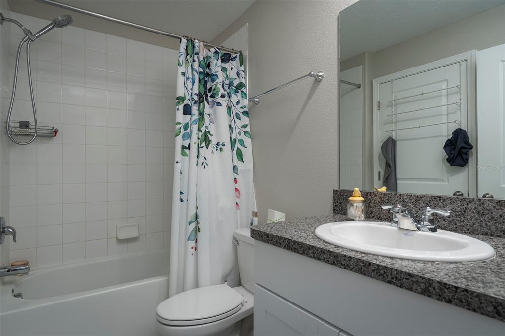 11704 Castine Street New Port Richey, FL 34654 - Photo 30 of 31 a bathroom with a granite countertop sink toilet and shower