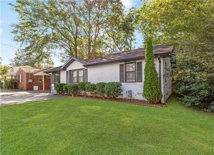 a front view of a house with a yard and trees