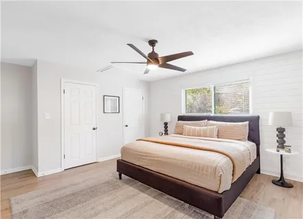 a bedroom with a bed and a ceiling fan in it