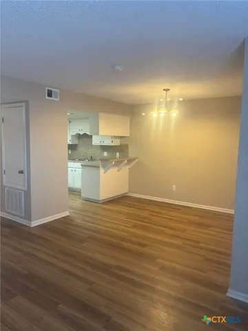a view of a room with wooden floor