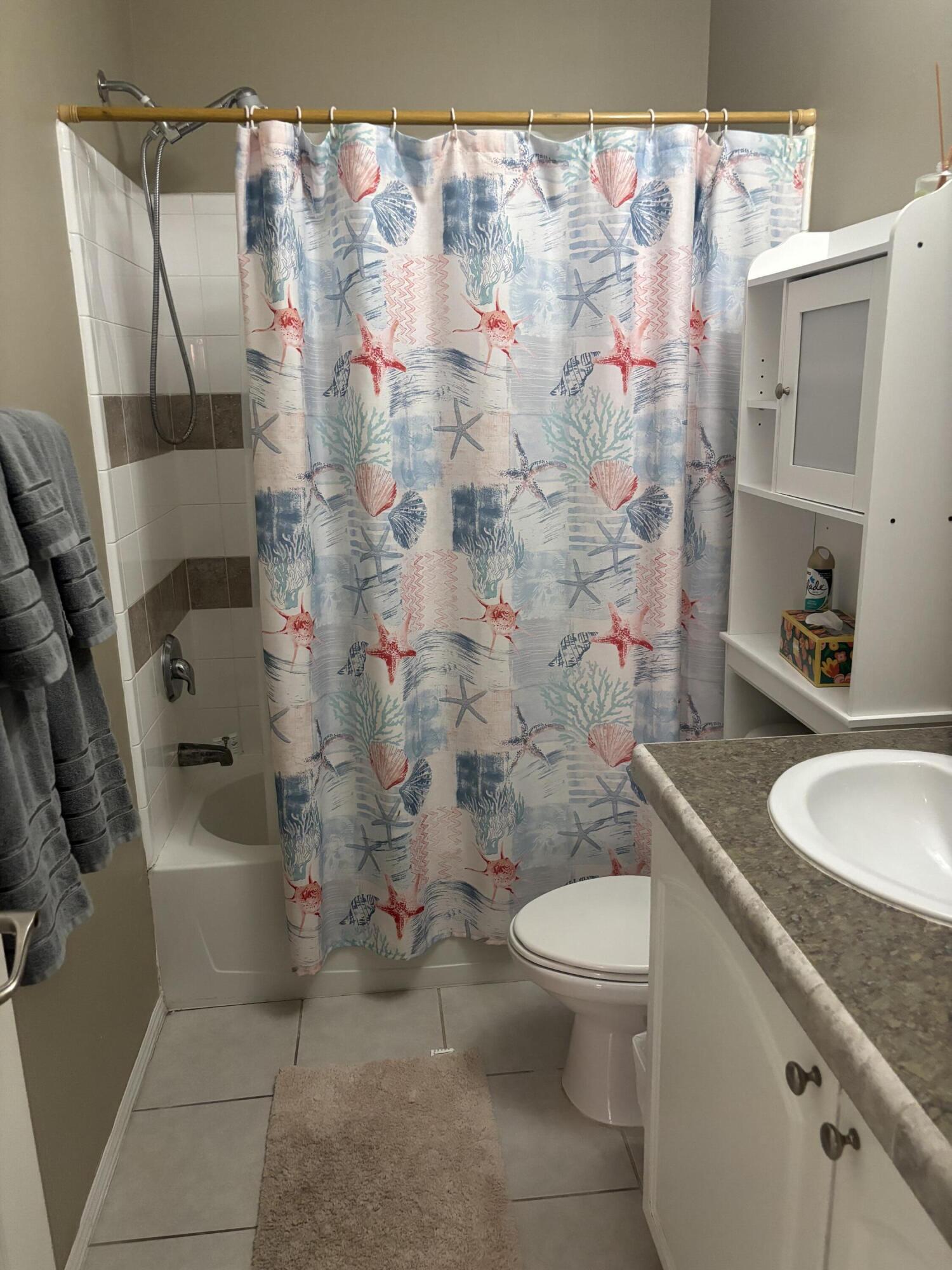 210 West 2nd Court Key Largo, FL 33037 - Photo 24 of 30 a bathroom with a sink a toilet and shower curtain