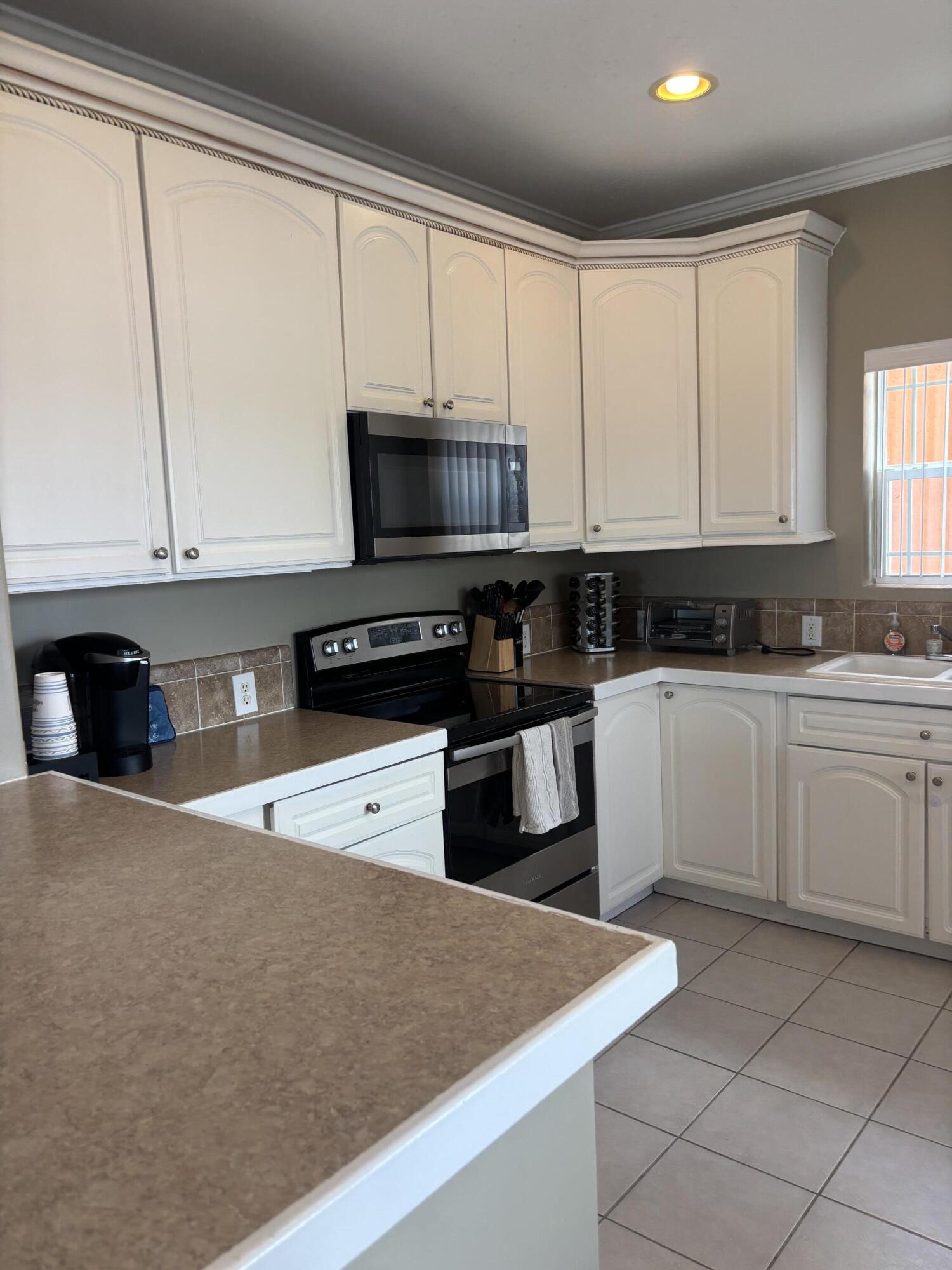 210 West 2nd Court Key Largo, FL 33037 - Photo 4 of 30 a kitchen with stainless steel appliances granite countertop a stove a sink and white cabinets