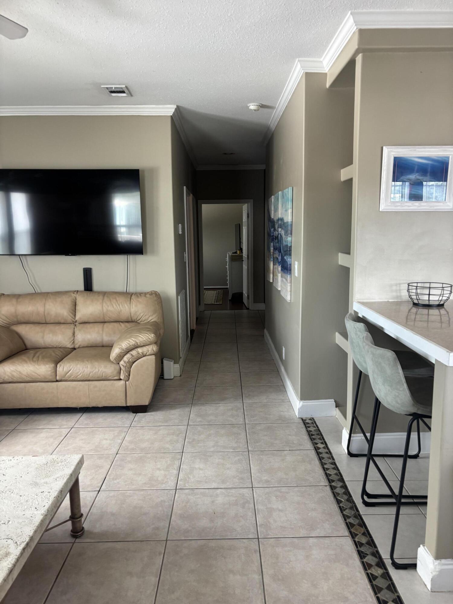 210 West 2nd Court Key Largo, FL 33037 - Photo 7 of 30 a living room with a couch and a flat screen tv