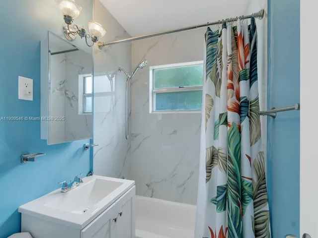 a bathroom with a sink a mirror and a shower