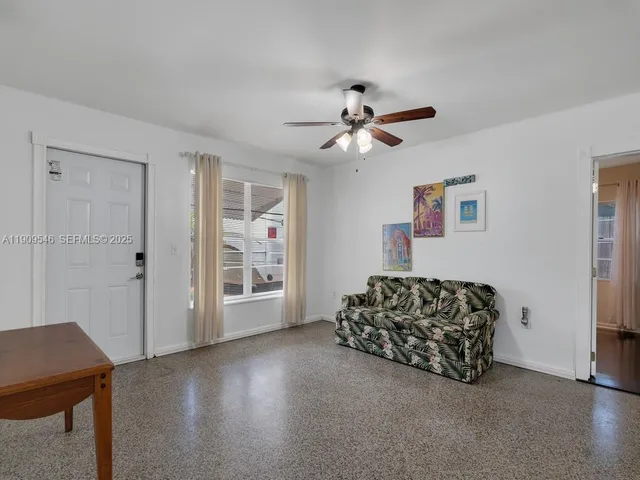 a living room with furniture ceiling fan and a window