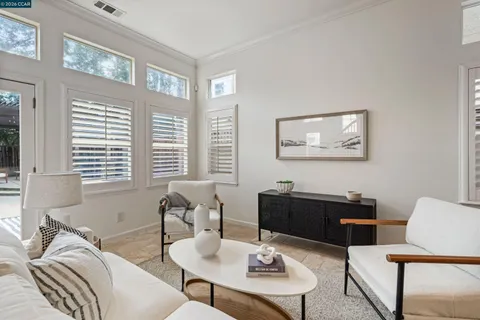 a living room with furniture and a dining table with kitchen view