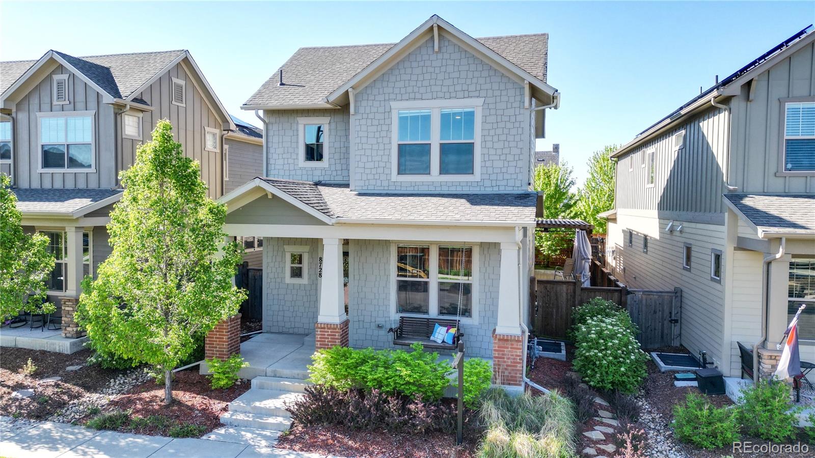 a front view of a house with a yard and potted plants