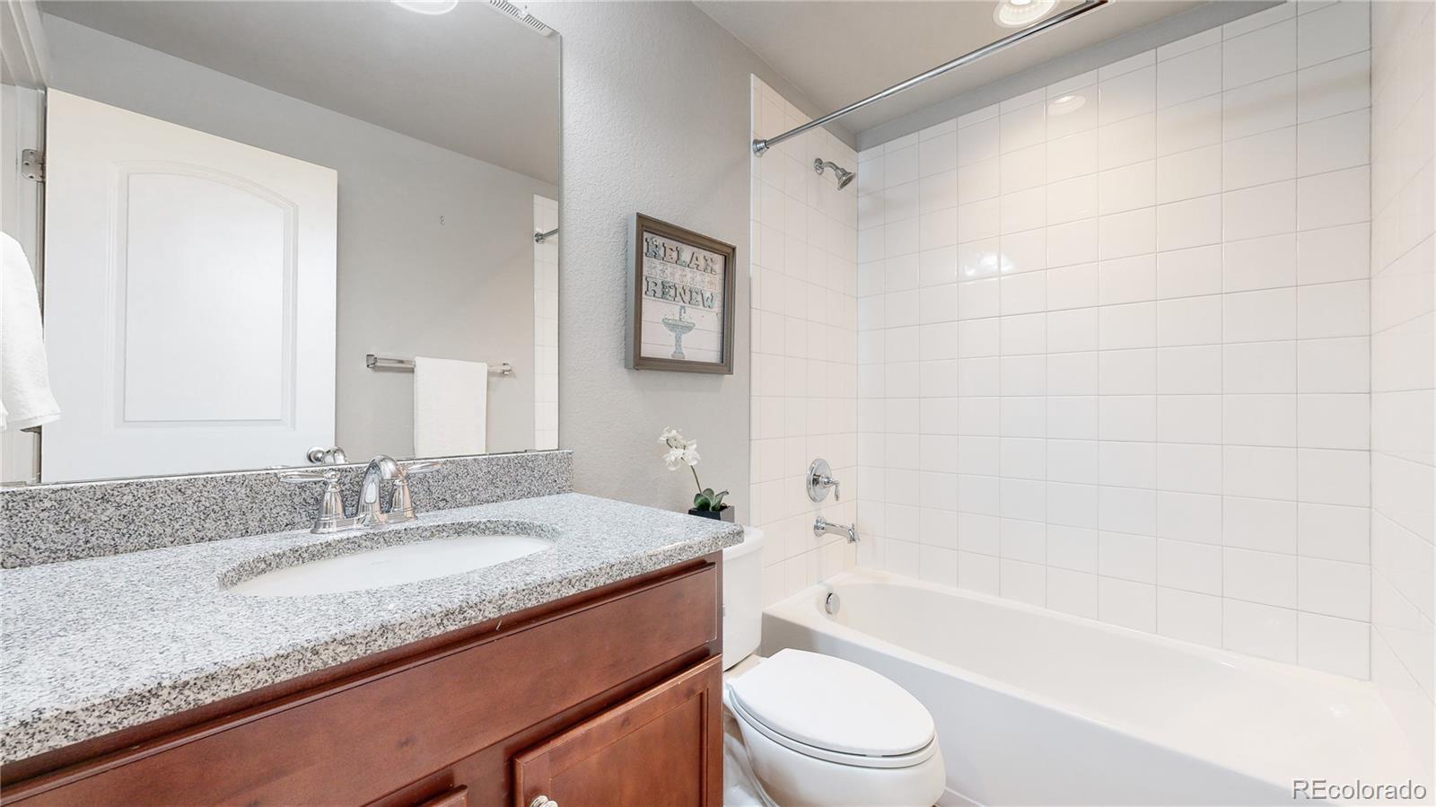 8728 54th Place Denver, CO 80238 - Photo 24 of 35 a bathroom with a granite countertop sink a toilet and bathtub