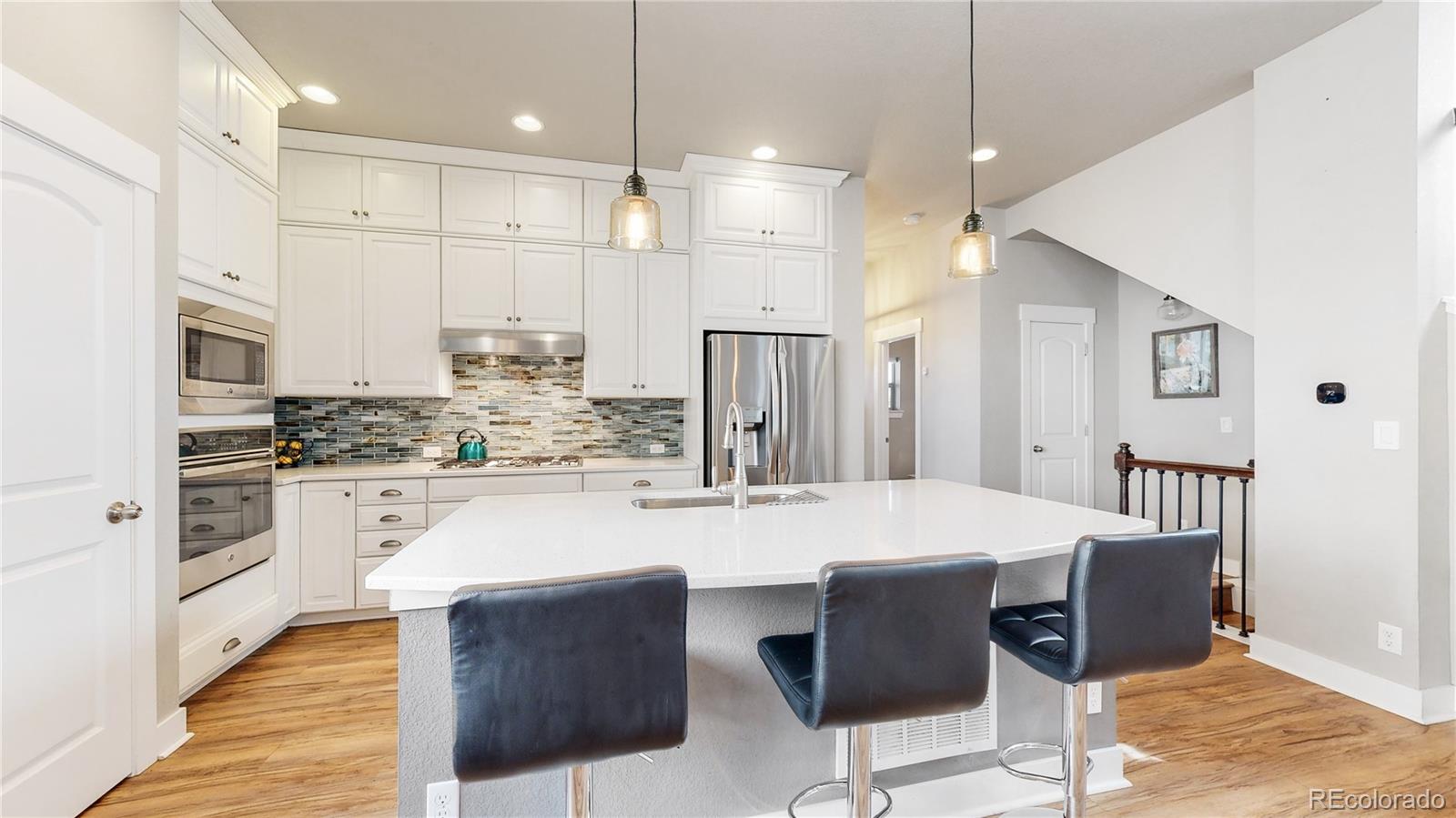 8728 54th Place Denver, CO 80238 - Photo 9 of 35 a large kitchen with cabinets table and chairs