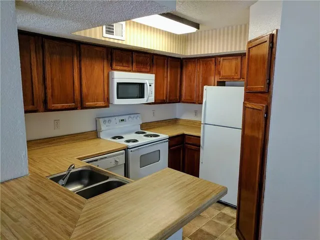 a kitchen with granite countertop a refrigerator stove and microwave