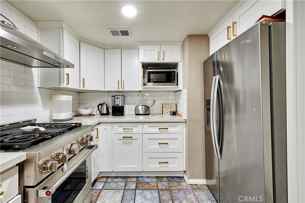 6949 Laguna Place, Unit B1 Rancho Cucamonga, CA 91701 - Photo 13 of 20 a kitchen with stainless steel appliances a refrigerator stove and microwave