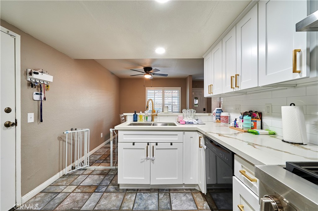 6949 Laguna Place, Unit B1 Rancho Cucamonga, CA 91701 - Photo 14 of 20 a kitchen with kitchen island granite countertop a sink cabinets and stainless steel appliances