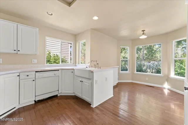 a kitchen with stainless steel appliances granite countertop a white cabinets a sink and a window