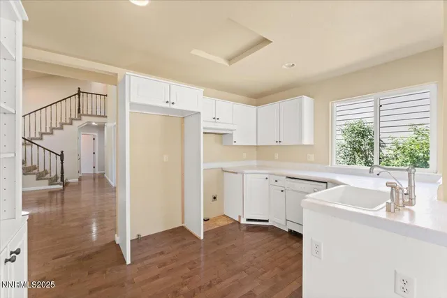 a kitchen with a sink cabinets stainless steel appliances and a window