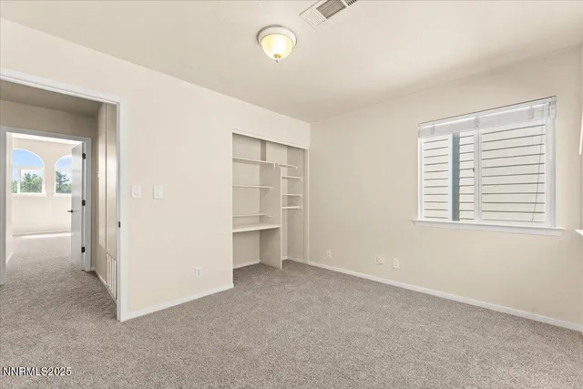 an empty room with windows and closet