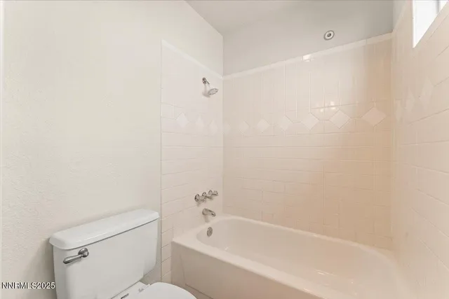 a white bath tub sitting next to a white toilet