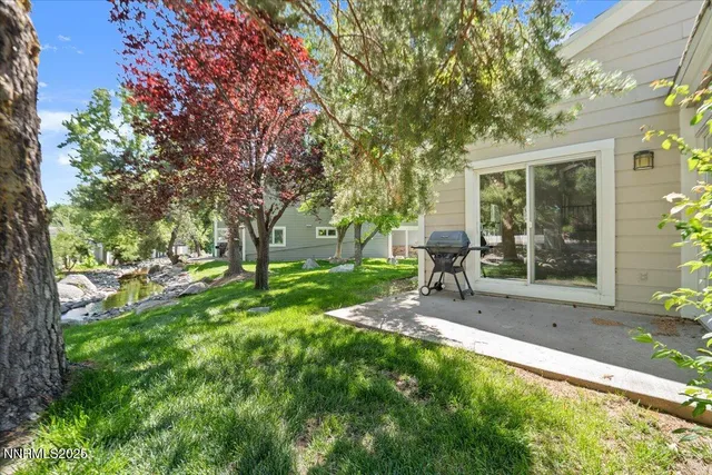 a view of a chair and table in backyard of the house