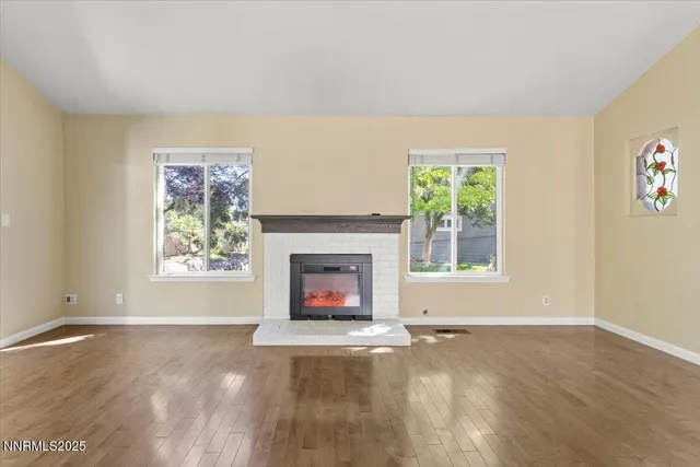 a view of an empty room with a window and fireplace