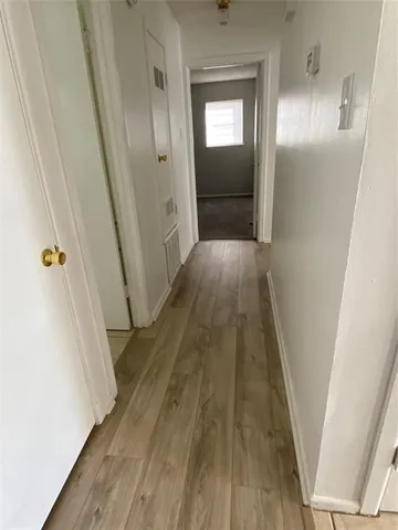 a view of a hallway with wooden floor and staircase