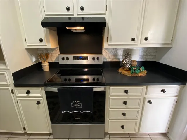 a stove top oven sitting inside of a kitchen