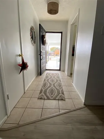 a view of a hallway to a bedroom with windows