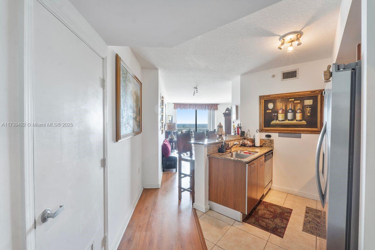 9055 Southwest 73rd Court, Unit 903 Miami, FL 33156 - Photo 20 of 24 a view of a kitchen with stainless steel appliances granite countertop a refrigerator and a stove top oven