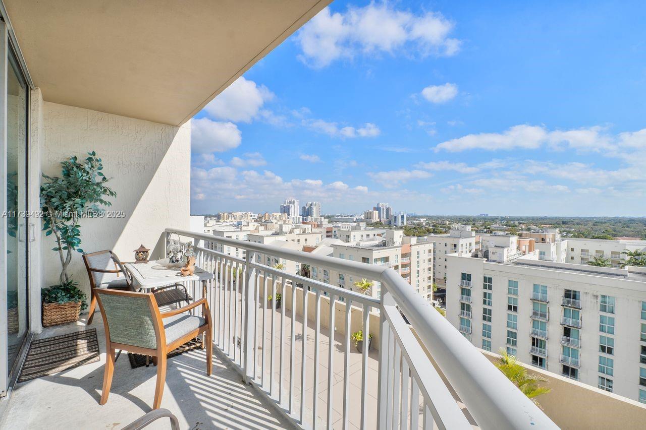 9055 Southwest 73rd Court, Unit 903 Miami, FL 33156 - Photo 7 of 24 a view of a balcony with wooden chairs