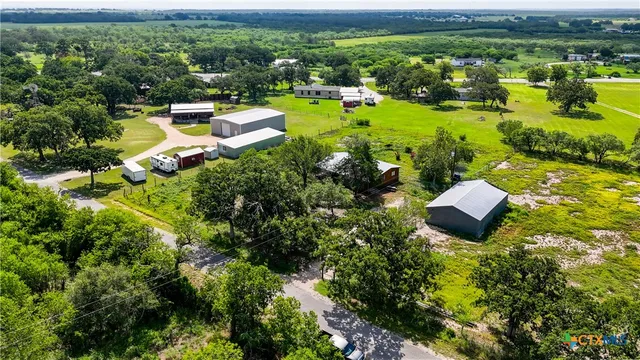 an aerial view of a house with a garden and lake view