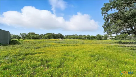 a view of a green field with an trees in the background