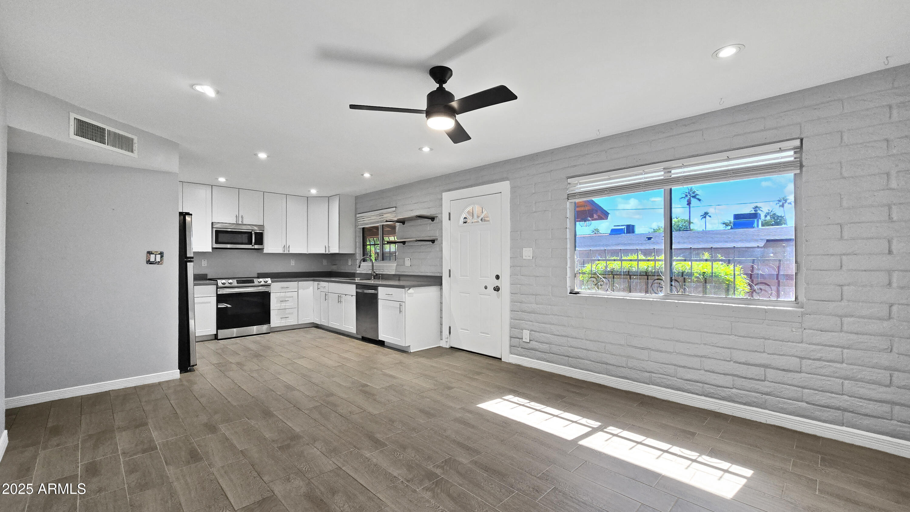 6739 North 16th Street, Unit 14 Phoenix, AZ 85016 - Photo 4 of 19 a kitchen with stainless steel appliances kitchen island granite countertop a stove and a refrigerator