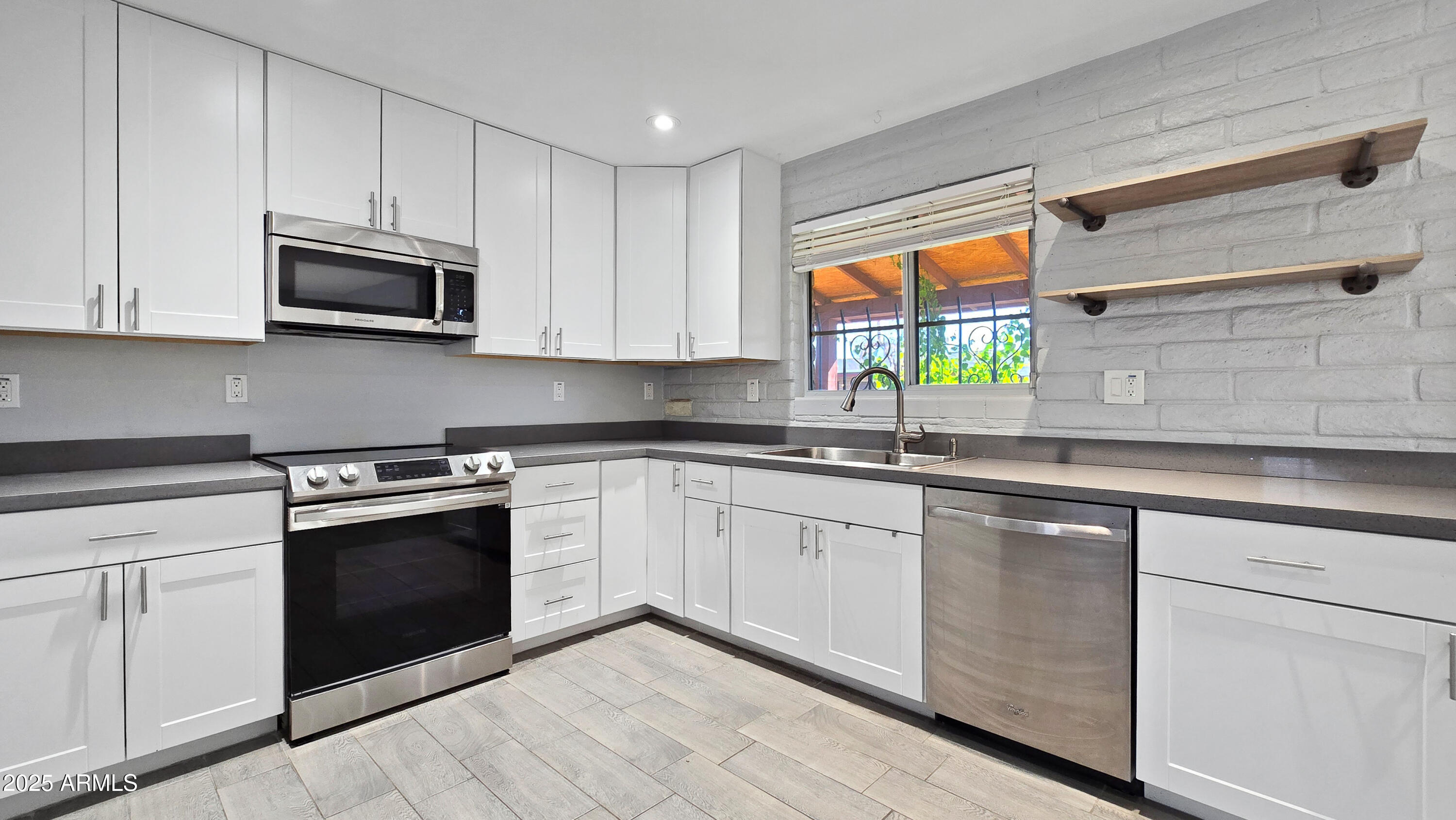 6739 North 16th Street, Unit 14 Phoenix, AZ 85016 - Photo 6 of 19 a kitchen with granite countertop white cabinets stainless steel appliances and a window