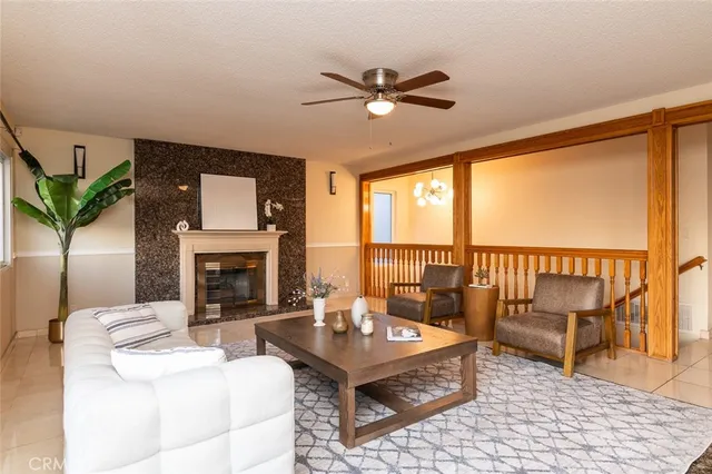 a living room with furniture a fireplace and a floor to ceiling window