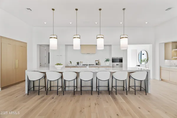 a large white kitchen with stainless steel appliances